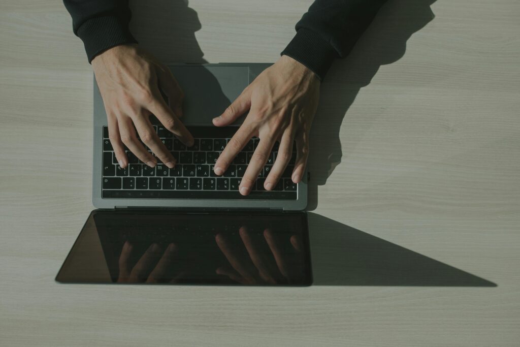 Jak zarabiać na blogu? Ile można zarobić i ile potrzeba wejść? czy na pisaniu bloga można zarobić – osoba pisząca na laptopie jako symbol zarabiania na blogu i content marketingu online